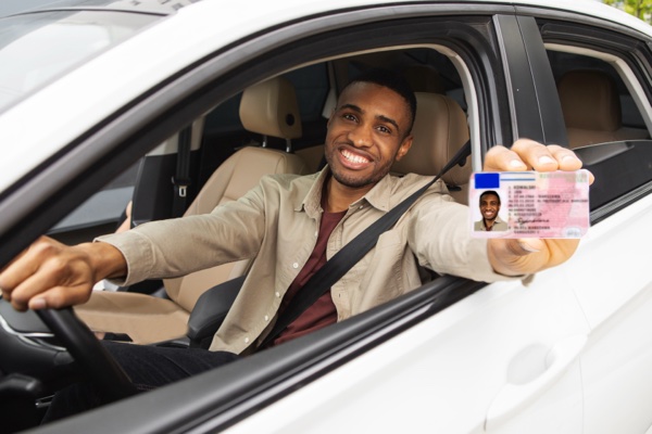 Professional showing driver's license from vehicle